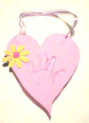 pink ceramic heart with the hand print of an infant