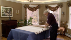 Arpin of RI packer in dining room spreading out export wrapping g paper on to the dining room table.