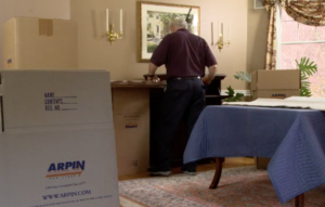 Arpin of RI packer in dining room carefully wrapping fragile items