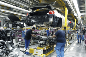 Image of workers assembling an automobile on an efficient assembly line in a car manufacturing plant