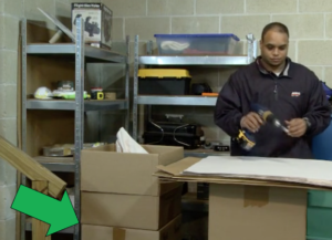 Arpin of RI packer in a basement placing items into a cartons that has been elevated to the proper working height